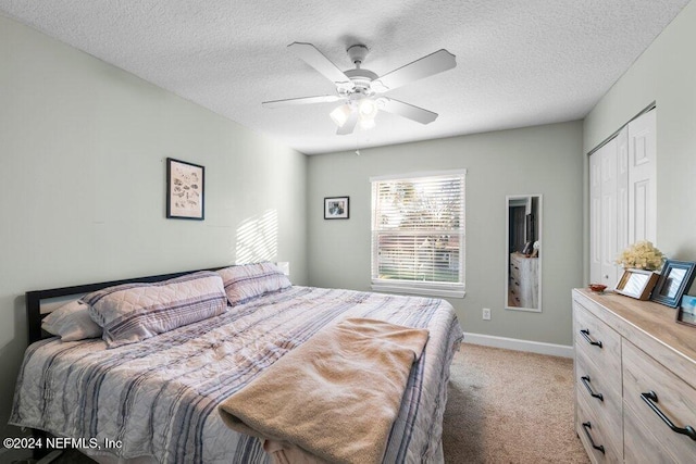 carpeted bedroom featuring ceiling fan, a closet, and a textured ceiling