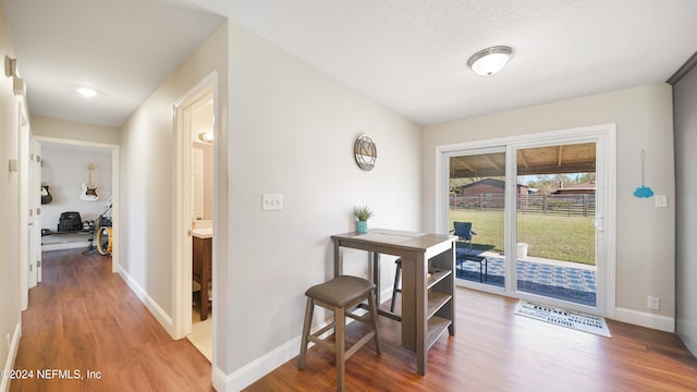 hall with wood-type flooring and a textured ceiling