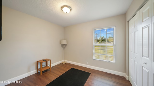 exercise area with dark wood-type flooring and a textured ceiling