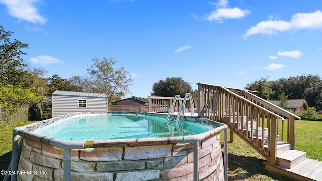 view of pool with a deck and a storage shed