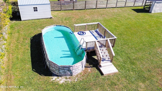 view of swimming pool featuring a yard and a storage unit