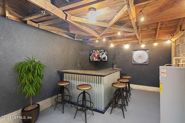 bar featuring water heater and concrete floors