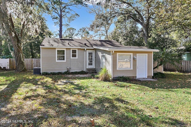 back of property with a lawn and cooling unit