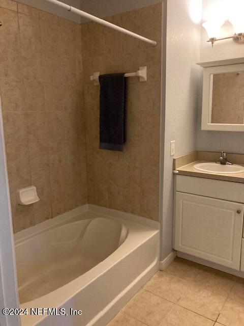 bathroom featuring vanity, tiled shower / bath combo, and tile patterned floors