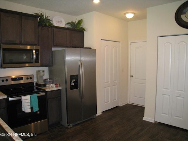 kitchen with dark brown cabinetry, dark hardwood / wood-style flooring, and stainless steel appliances