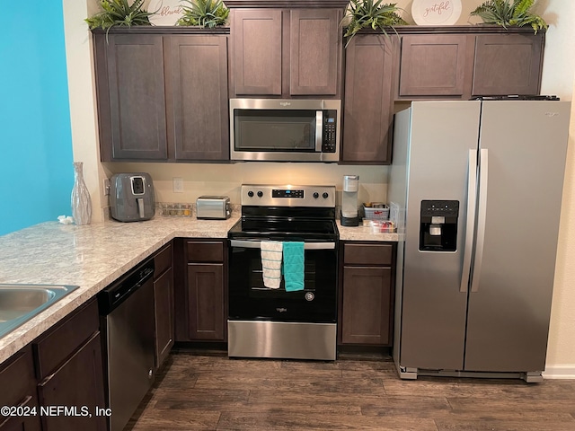 kitchen featuring appliances with stainless steel finishes, dark hardwood / wood-style flooring, and dark brown cabinetry