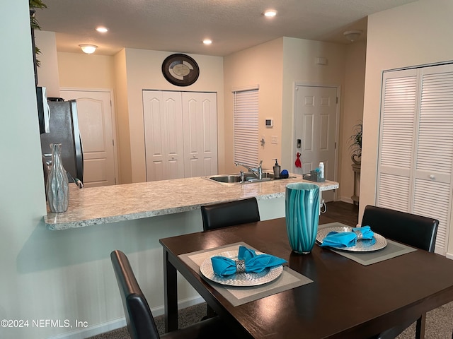 dining area featuring sink and a textured ceiling