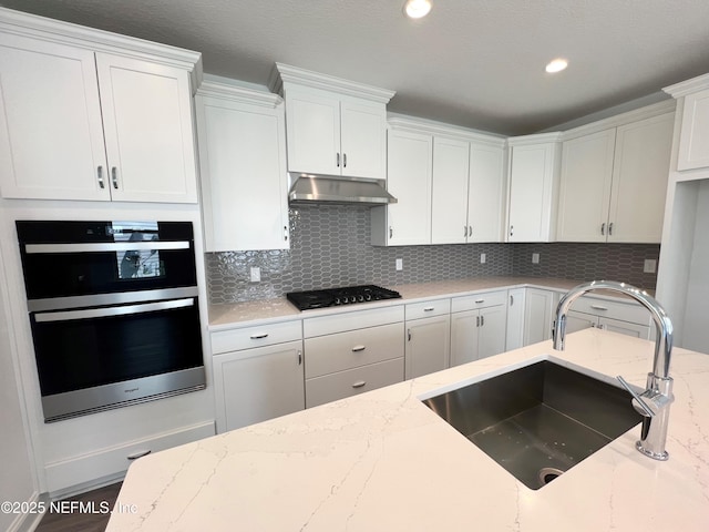 88 Latham Dr, Ponte Vedra, FL 32081 - kitchen featuring black gas stovetop, a sink, under cabinet range hood, double oven, and white cabinets