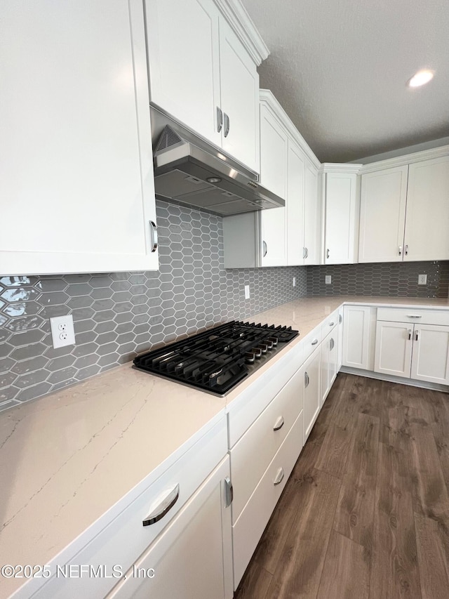 88 Latham Dr, Ponte Vedra, FL 32081 - kitchen with under cabinet range hood, stainless steel gas stovetop, white cabinets, and dark wood-style floors