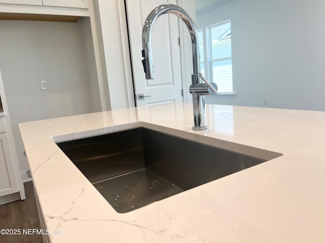 88 Latham Dr, Ponte Vedra, FL 32081 - kitchen view of a sink, light stone countertops, and white cabinetry