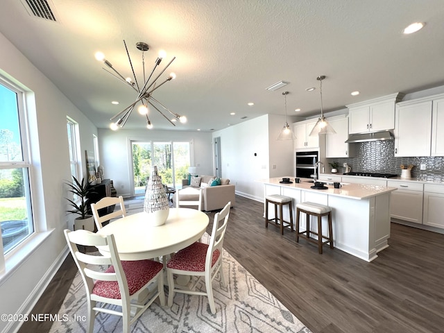 88 Latham Dr, Ponte Vedra, FL 32081 - dining space featuring dark wood-type flooring, a chandelier, baseboards, recessed lighting, and a textured ceiling