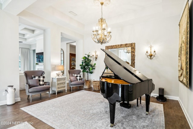 sitting room with a chandelier, dark hardwood / wood-style floors, and a raised ceiling