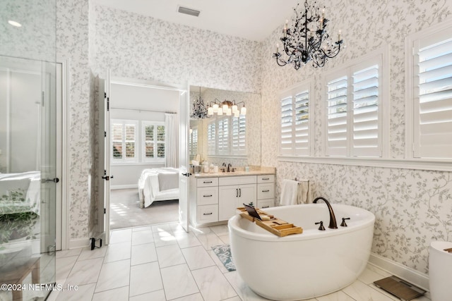 bathroom with a tub to relax in, vanity, a healthy amount of sunlight, and a notable chandelier