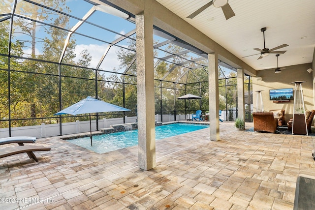 view of pool with pool water feature, ceiling fan, a lanai, and a patio