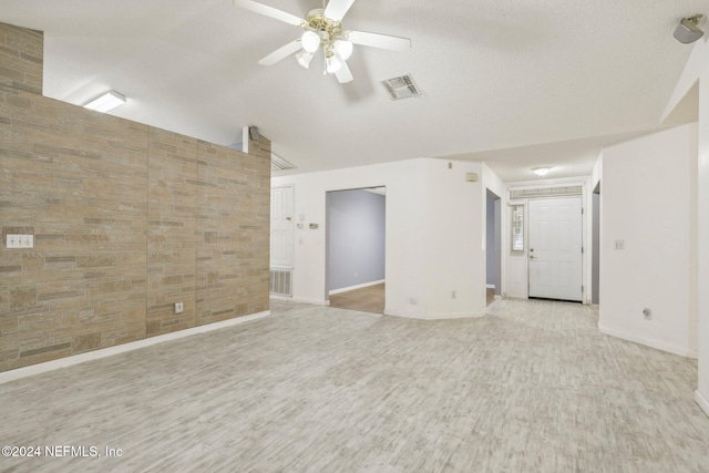 spare room with a textured ceiling, light hardwood / wood-style floors, and ceiling fan