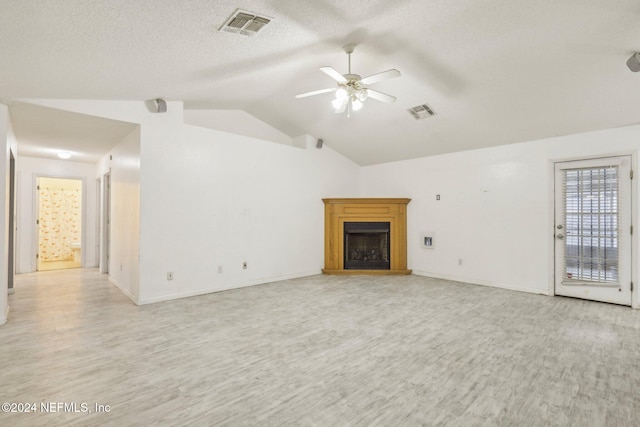 unfurnished living room with a textured ceiling, light hardwood / wood-style flooring, vaulted ceiling, and ceiling fan