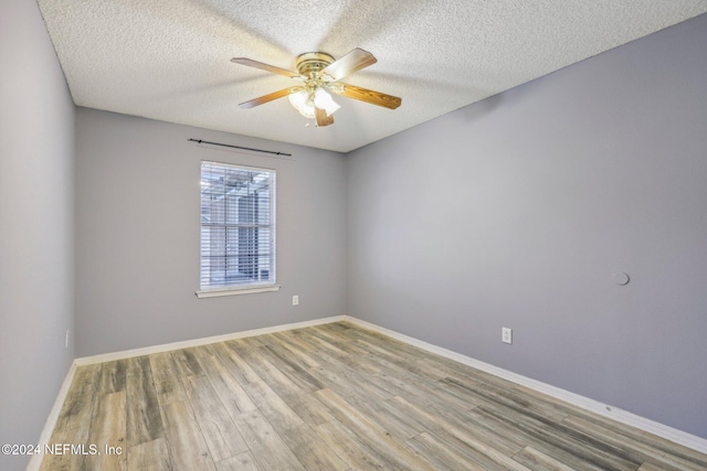 spare room with ceiling fan, light wood-type flooring, and a textured ceiling