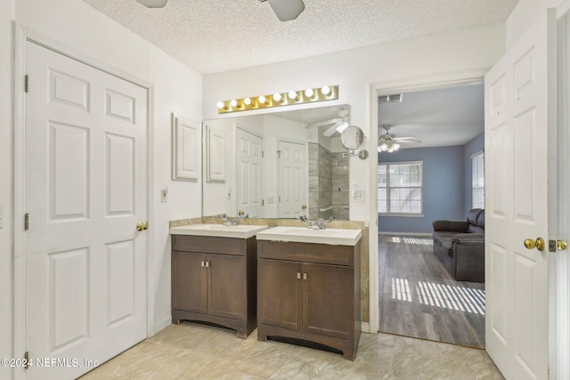 bathroom with ceiling fan, vanity, wood-type flooring, and a textured ceiling