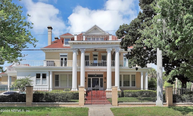 neoclassical home featuring a porch, a balcony, and ceiling fan