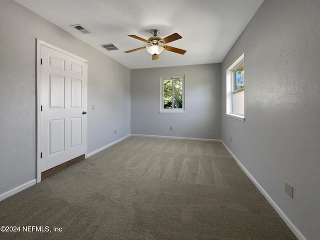 empty room featuring carpet flooring and ceiling fan