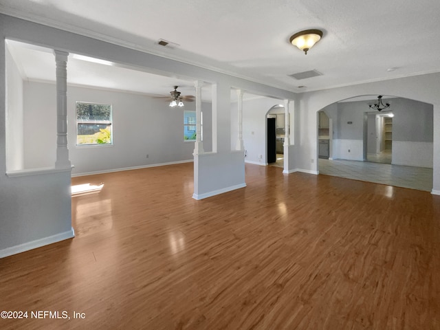 unfurnished living room featuring hardwood / wood-style floors, ceiling fan, and crown molding