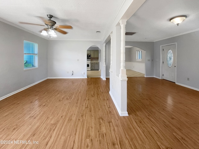 unfurnished living room featuring wood-type flooring, a textured ceiling, ceiling fan, and ornamental molding