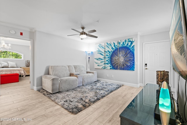 living room with crown molding, light hardwood / wood-style flooring, and ceiling fan with notable chandelier