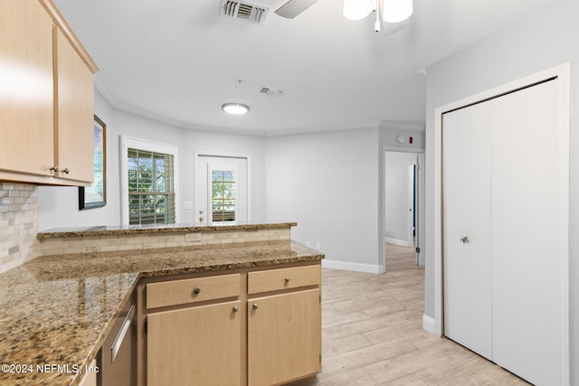 kitchen with light wood-type flooring, tasteful backsplash, light stone counters, ornamental molding, and light brown cabinets