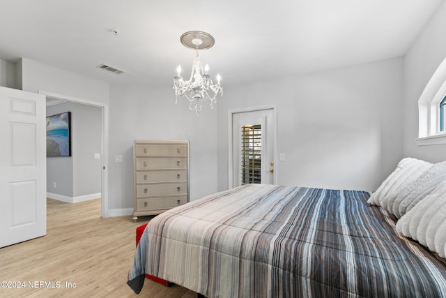 bedroom with a notable chandelier and light hardwood / wood-style floors