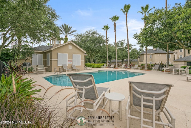 view of pool with a patio and a grill