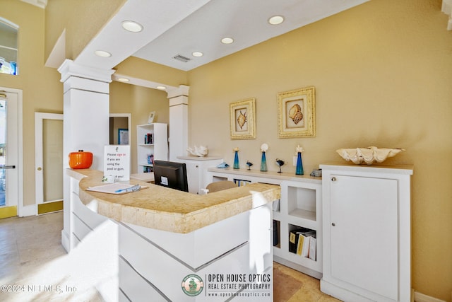 kitchen featuring white cabinetry and ornate columns