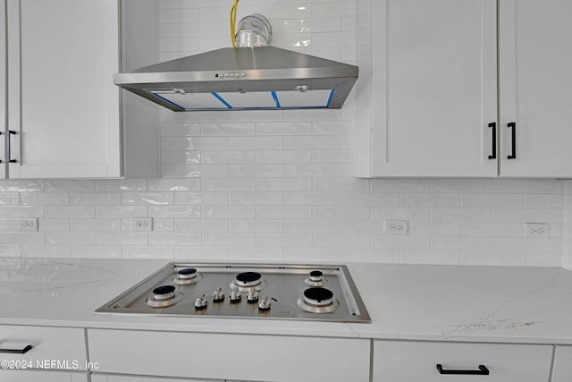 kitchen with backsplash, electric cooktop, light stone counters, and white cabinets