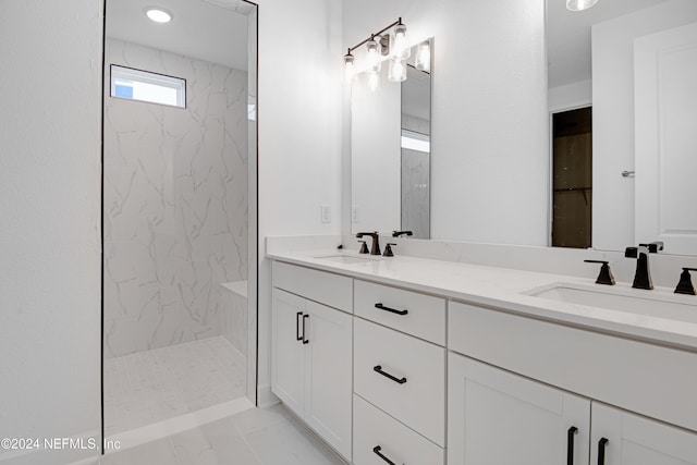 bathroom with a tile shower and vanity