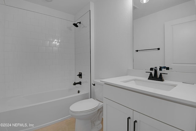 full bathroom featuring tiled shower / bath, tile patterned floors, vanity, and toilet