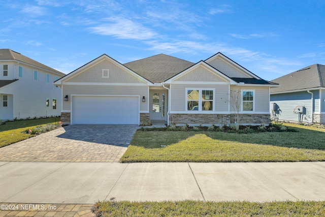 craftsman house featuring a garage and a front lawn