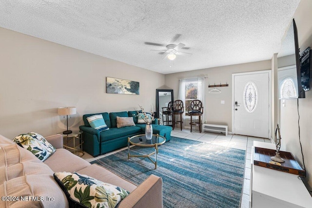 tiled living room featuring a textured ceiling, ceiling fan, and a healthy amount of sunlight