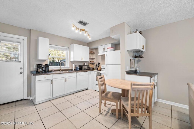 kitchen featuring white cabinets, white appliances, sink, and light tile patterned floors