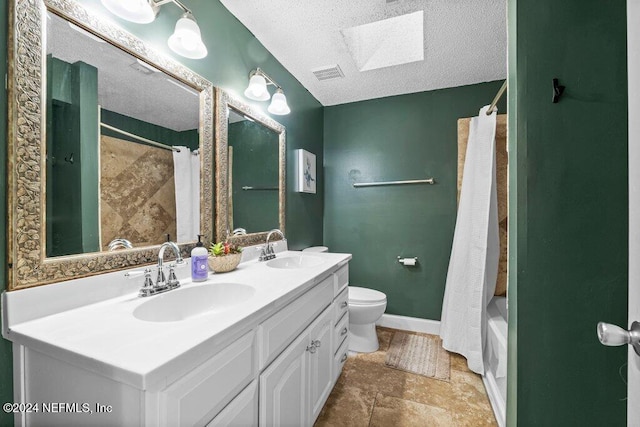 full bathroom featuring a skylight, shower / bathtub combination with curtain, a textured ceiling, toilet, and vanity