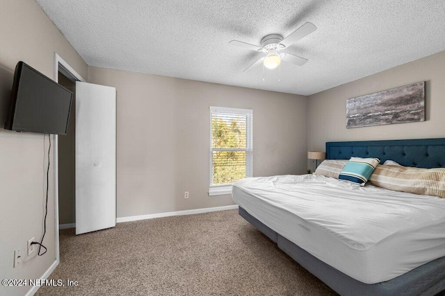 carpeted bedroom featuring ceiling fan and a textured ceiling