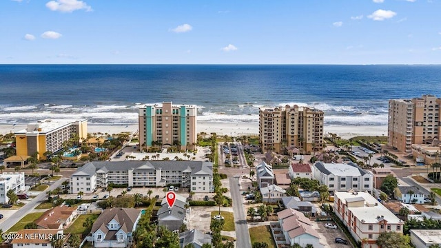 drone / aerial view with a water view and a beach view