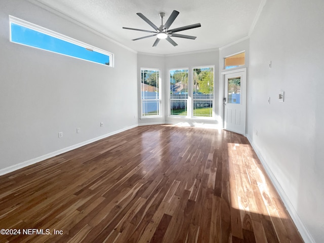 spare room with a textured ceiling, dark hardwood / wood-style floors, ceiling fan, and crown molding