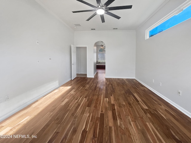 empty room with ceiling fan, ornamental molding, and dark wood-type flooring