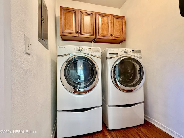 laundry room with cabinets, dark wood-type flooring, and washing machine and clothes dryer