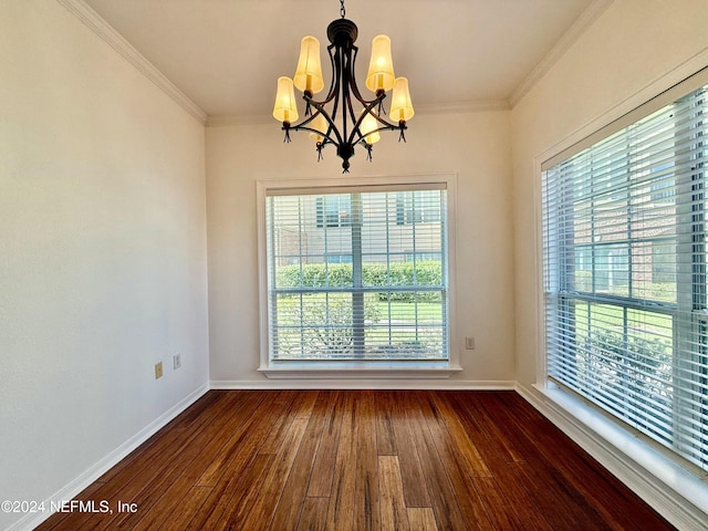 empty room with ornamental molding, dark hardwood / wood-style floors, a wealth of natural light, and a notable chandelier