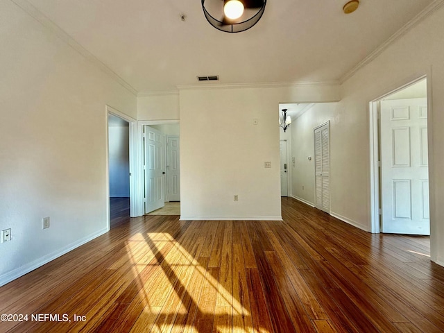 empty room featuring hardwood / wood-style floors and ornamental molding