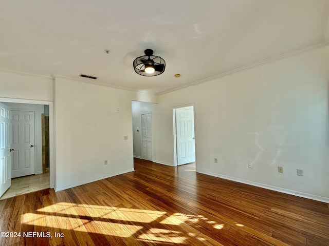 unfurnished room featuring wood-type flooring, ceiling fan, and crown molding