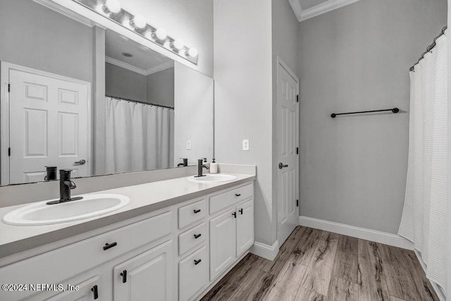 bathroom with vanity, hardwood / wood-style flooring, and crown molding