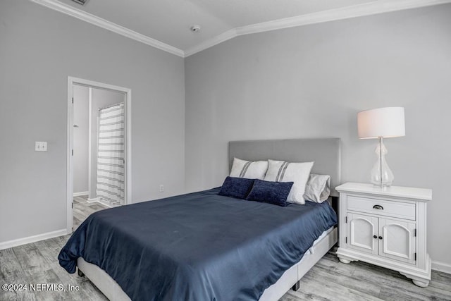 bedroom featuring crown molding, light hardwood / wood-style floors, and lofted ceiling