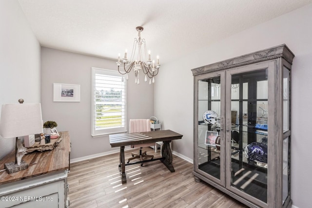 office space with light hardwood / wood-style floors, a textured ceiling, and a chandelier