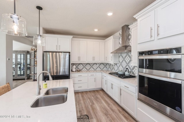 kitchen featuring white cabinets, hanging light fixtures, sink, and appliances with stainless steel finishes